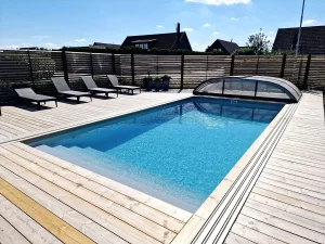 PP POOL PAKET 3 X 6 X 1,5M HELGAVELTRAPPA med ett trädäck, solstolar och ett stängsel.